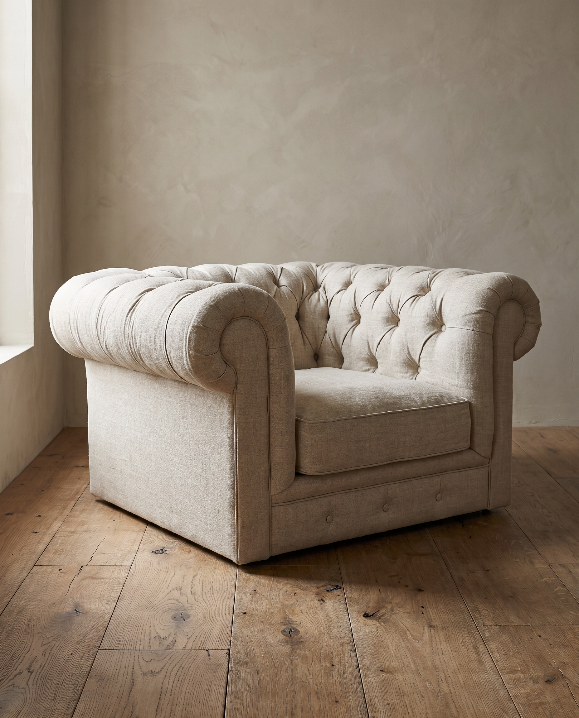 Side three-quarter view of the linen chesterfield chair showing its plain outer arm and low base