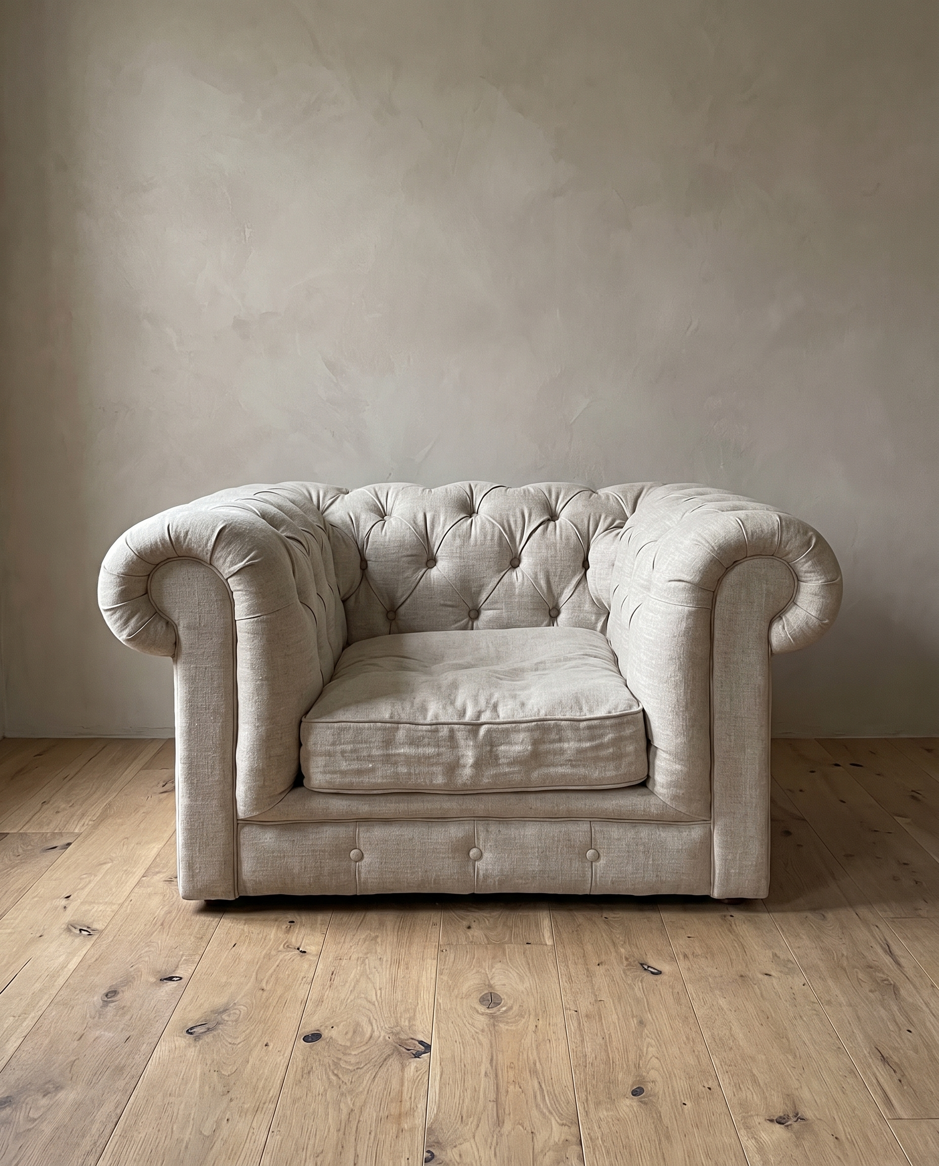 The chesterfield chair from the front, showing the deep diamond tufting, rolled arms, soft seat cushion and buttoned base rail