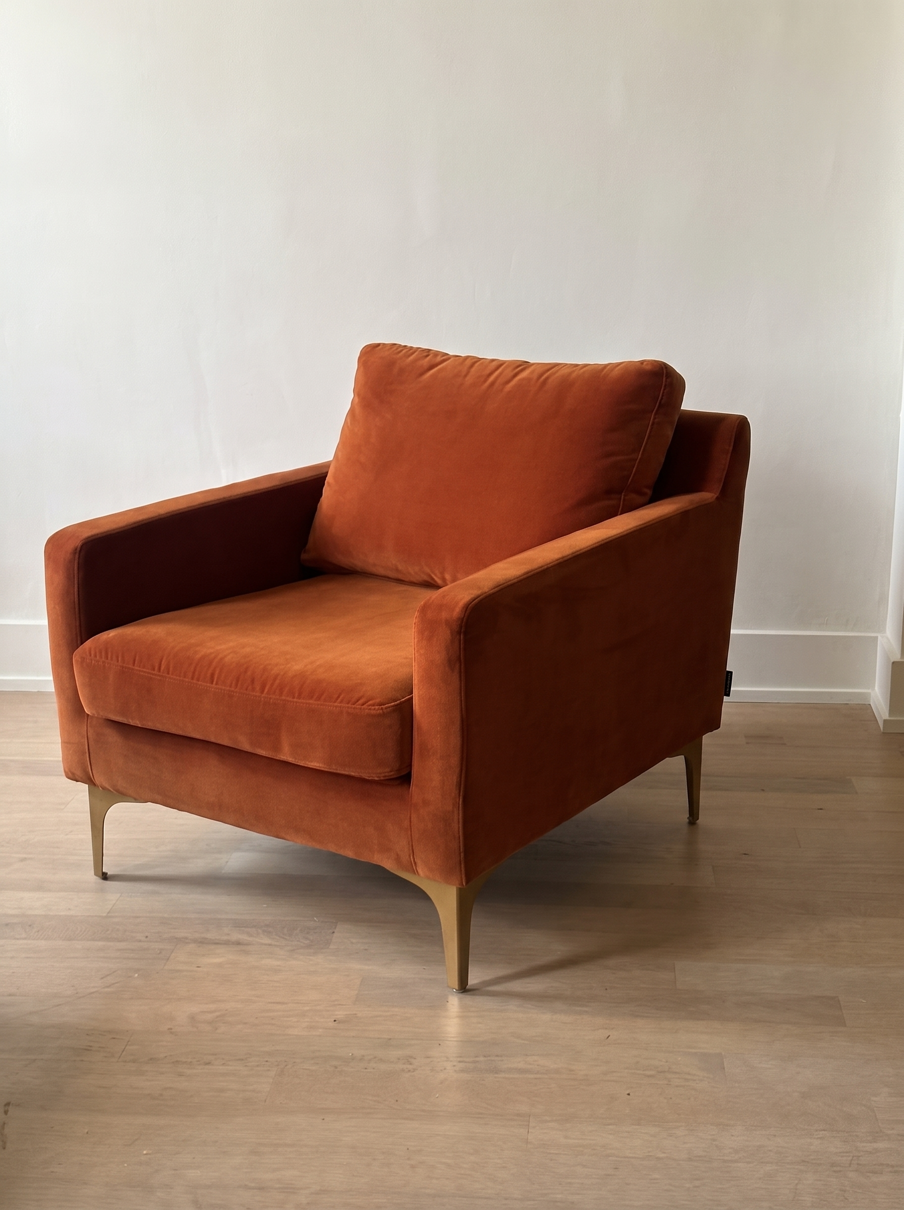 Rust velvet armchair, wide three-quarter view from the left