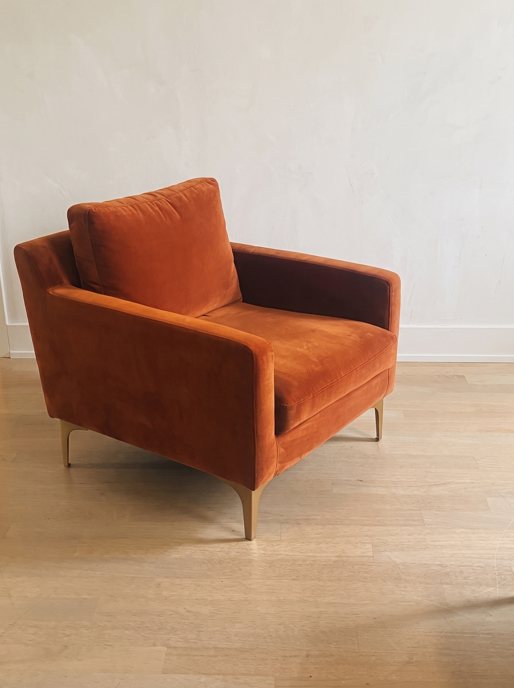 Rust velvet armchair, three-quarter view, on a light oak floor