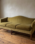 Three-quarter view of the chartreuse camelback sofa with rolled scroll arms