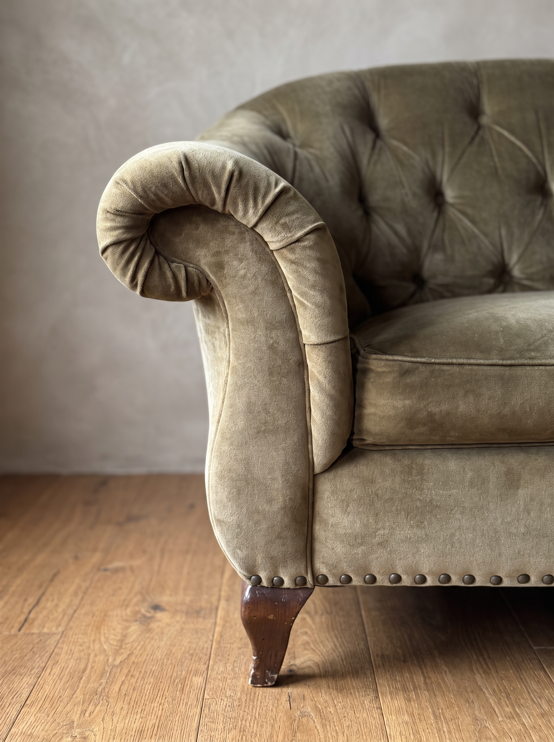 Detail of the rolled scroll arm, brass nailheads and walnut leg