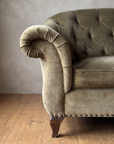 Detail of the rolled scroll arm, brass nailheads and walnut leg