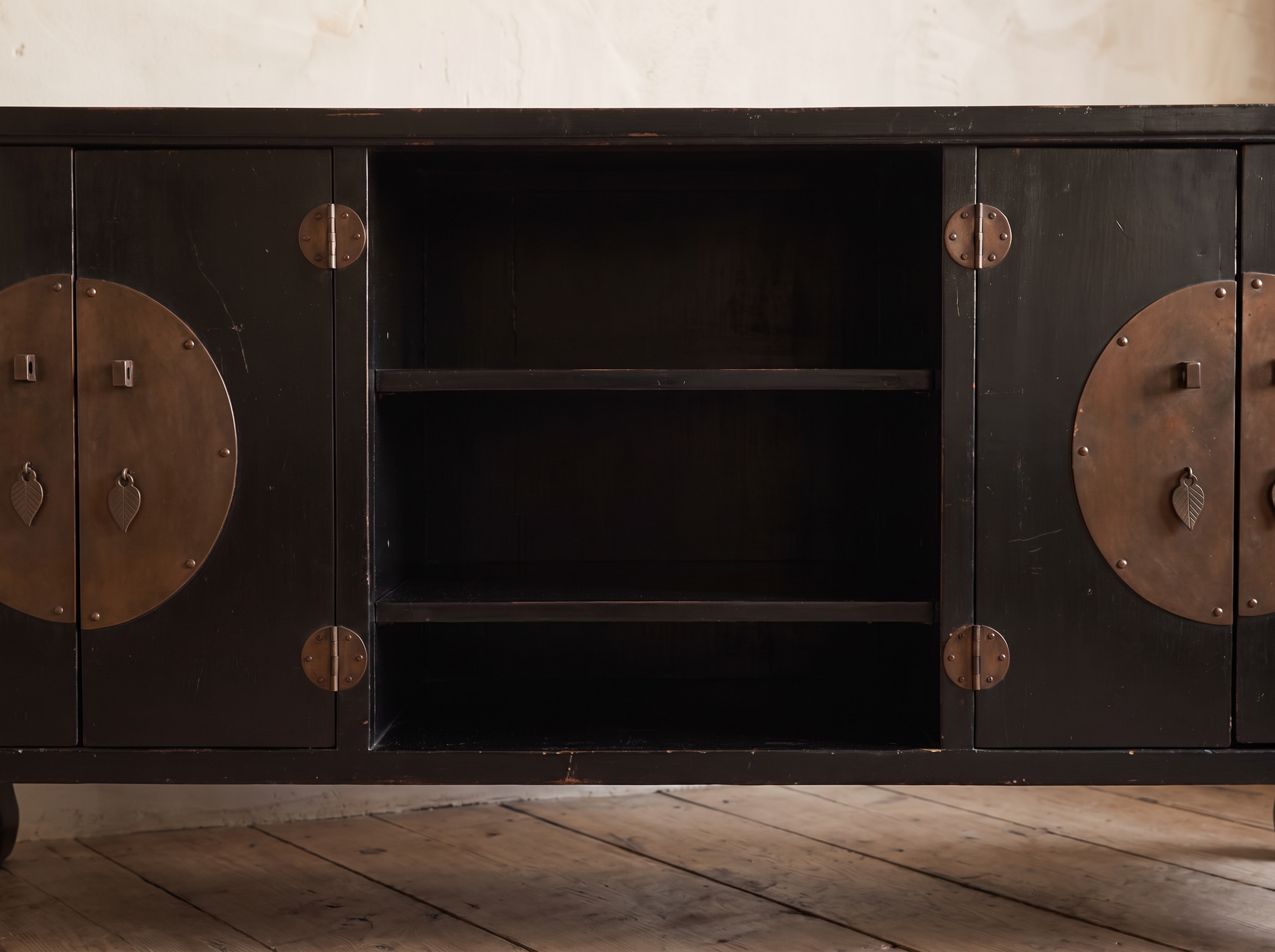 Detail of the open center shelves and aged bronze round door plates with leaf pulls