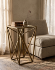 Scintilla brass side table beside a linen chair