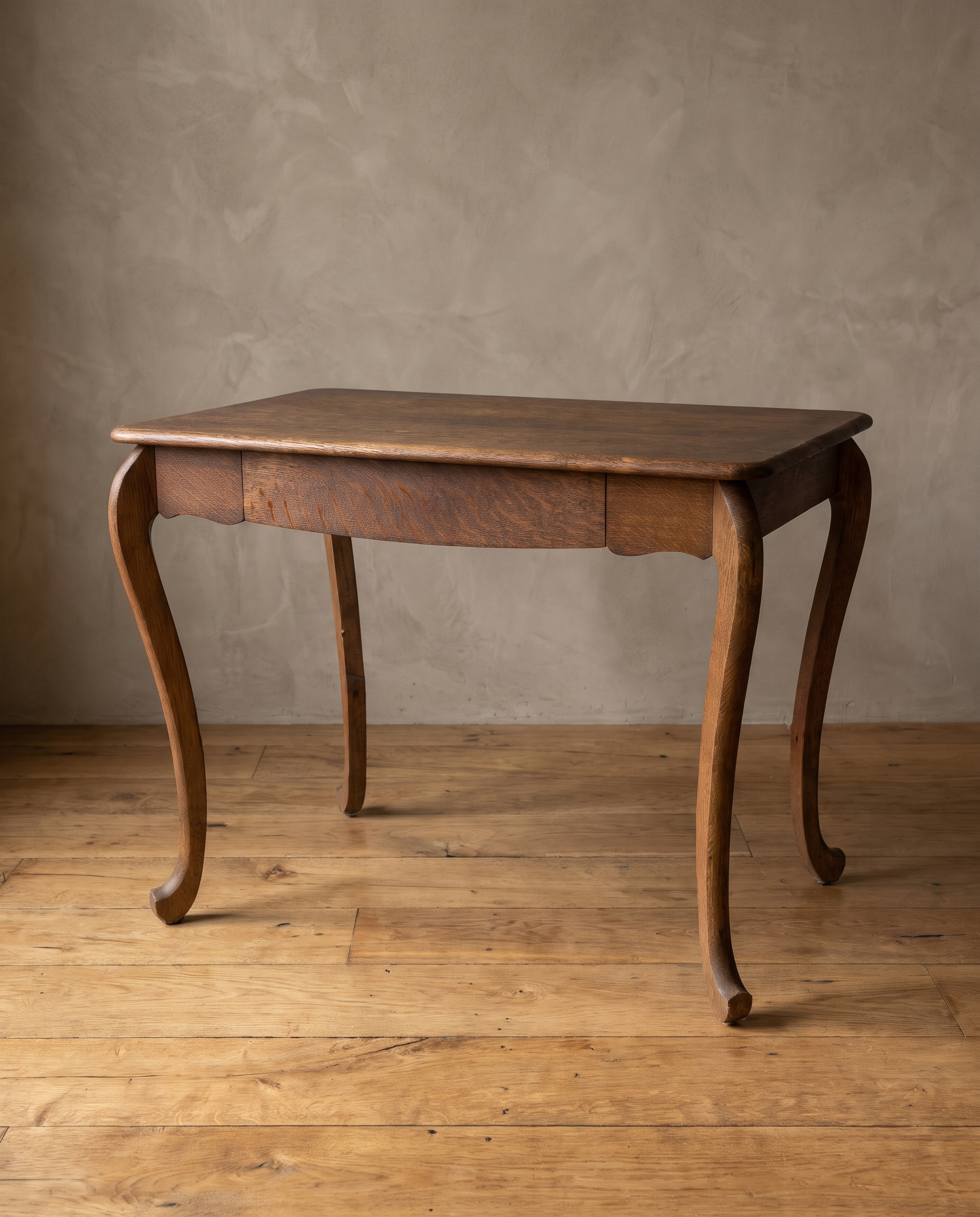 Antique tiger oak writing desk with cabriole scroll legs, three-quarter view in a plaster room with a reclaimed wood floor