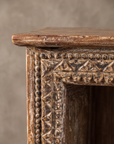 Close-up of the carved top corner: beads, triangles and scallops in a worn pale finish.