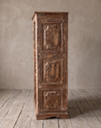 Side of the bookcase with three raised carved panels and a shaped plinth.