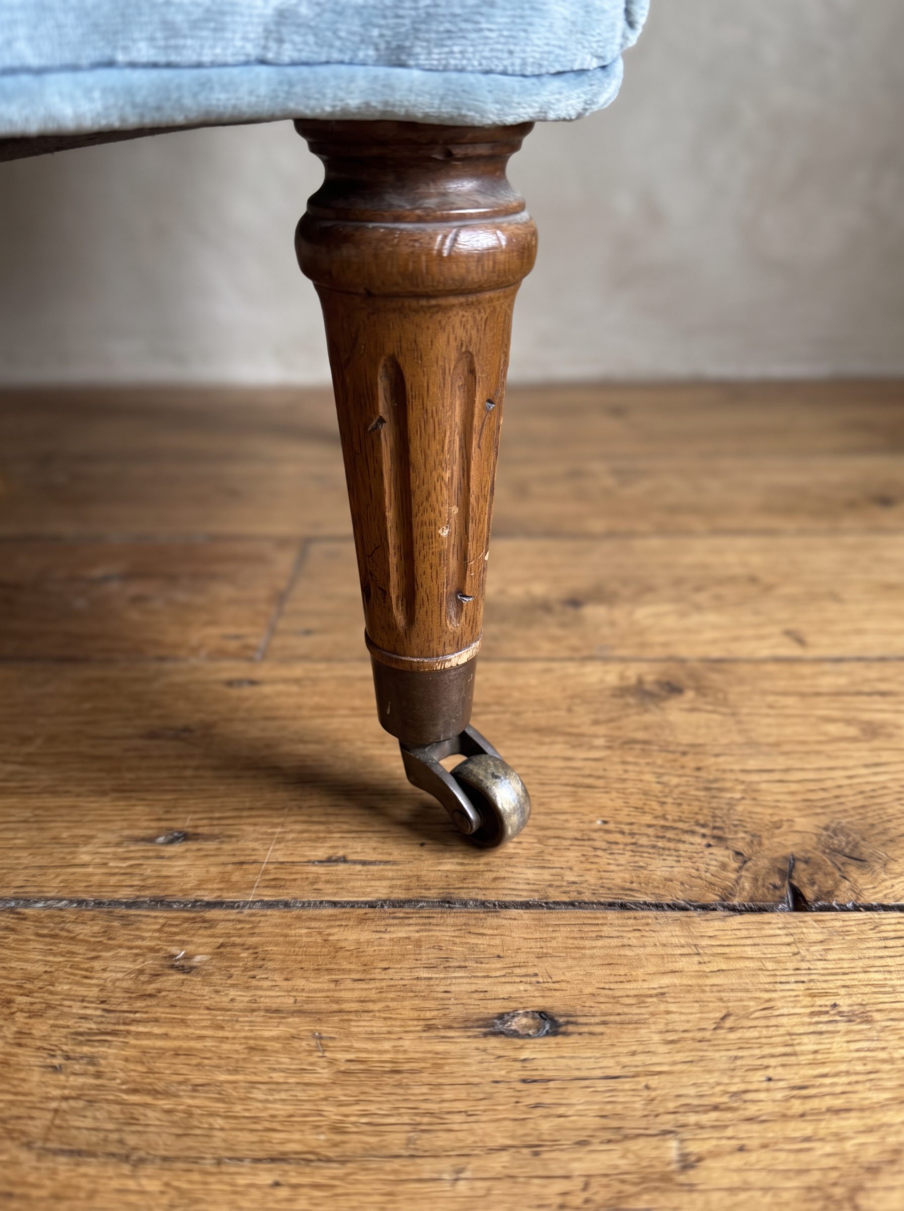 Close-up of the fluted walnut leg on a brass caster