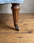 Close-up of the fluted walnut leg on a brass caster