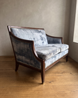 Ice blue velvet loveseat, three-quarter view from the right showing the sabre arm