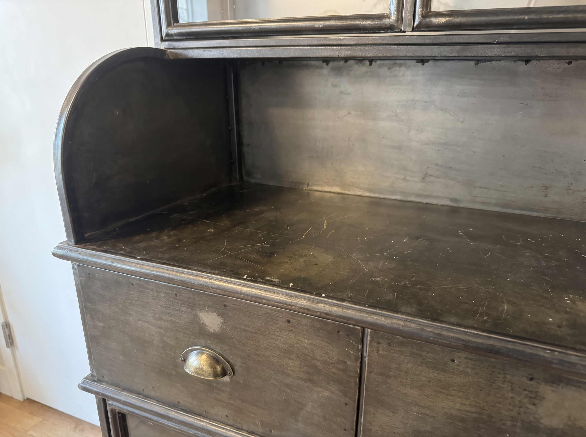 Detail of the curved steel side panel and the counter's honest wear