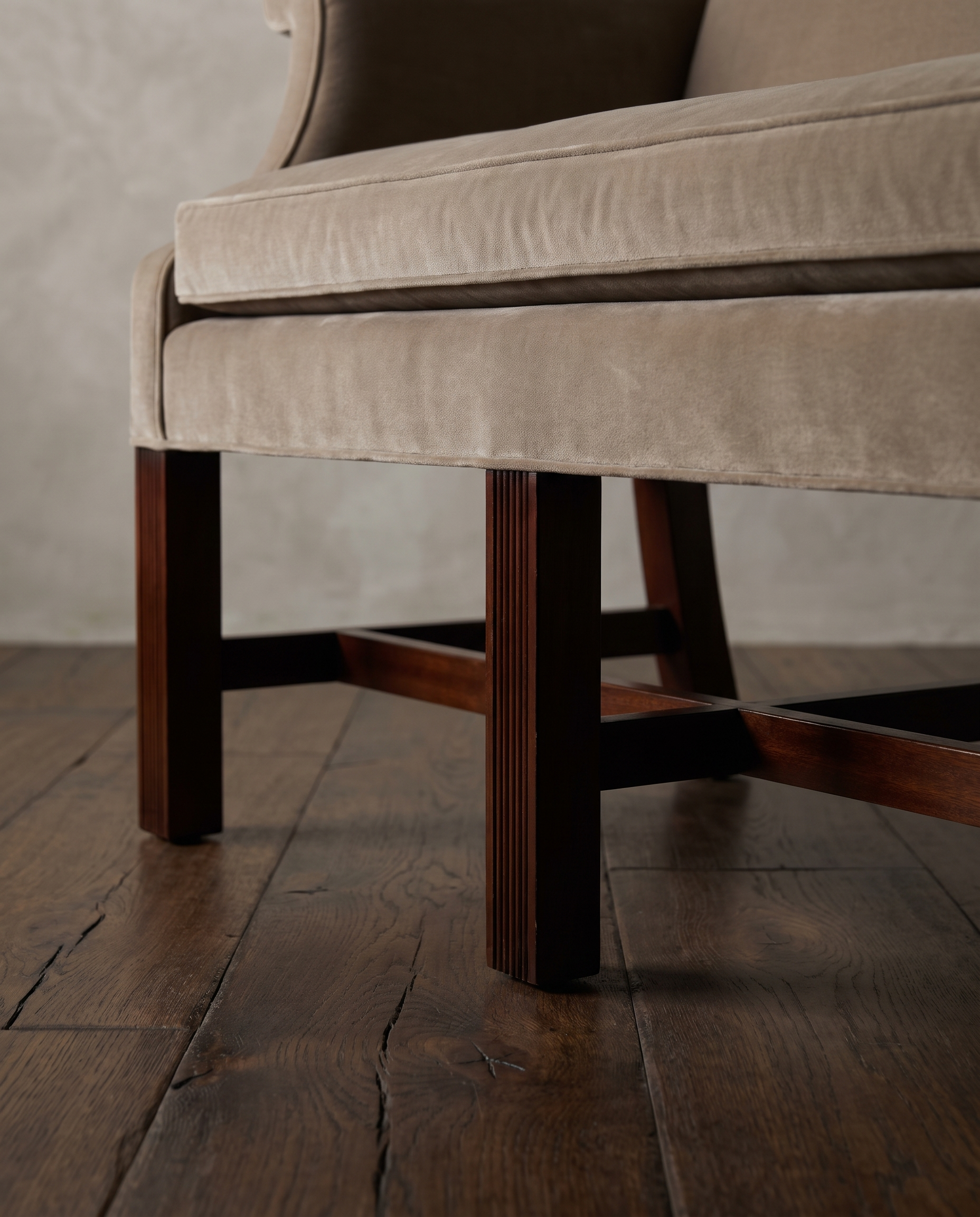 Low view of the mahogany legs and H-stretchers under the velvet seat rail