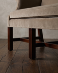 Low view of the mahogany legs and H-stretchers under the velvet seat rail