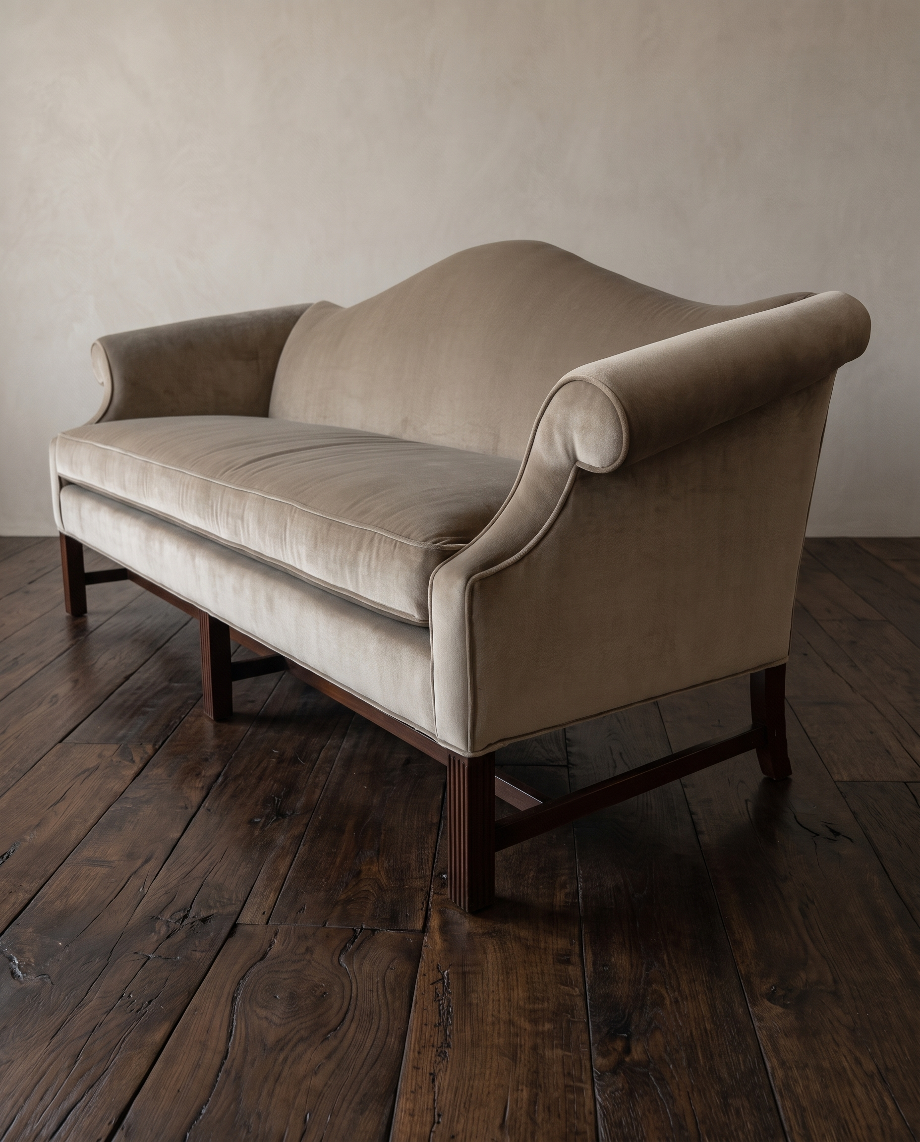 Three-quarter view of the tan velvet camelback sofa from the right end