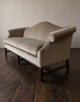 Three-quarter view of the tan velvet camelback sofa from the right end