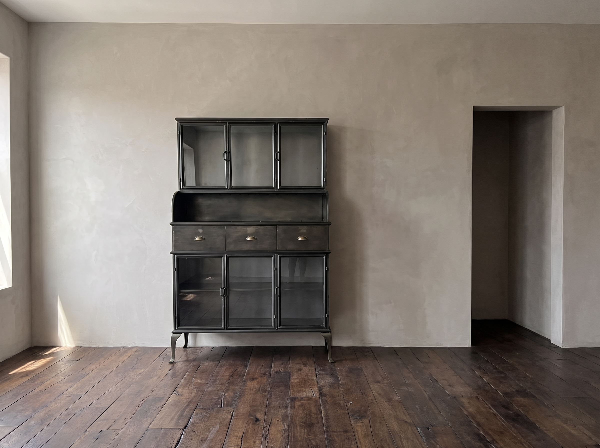 Steel hutch against a long plaster wall beside an open doorway, showing its near door height scale