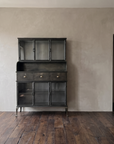 Steel hutch against a long plaster wall beside an open doorway, showing its near door height scale