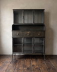 Apothecary steel hutch straight-on: three glass doors above, three drawers, three glass doors below, cabriole legs