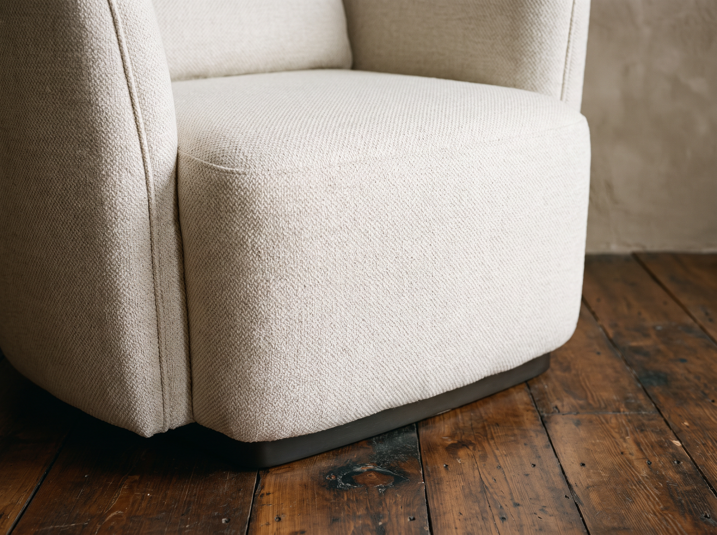 Close-up of the self-welt piping running down the armchair's rounded arm