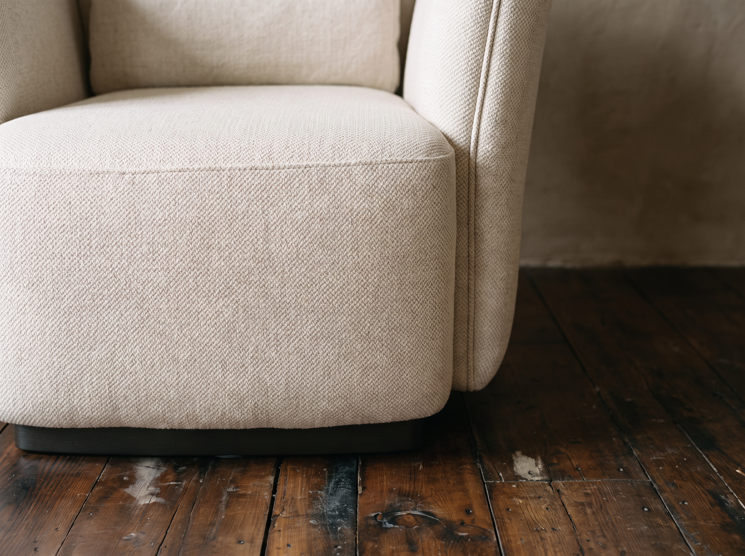 Close-up of oatmeal herringbone weave seat cushion and dark plinth base