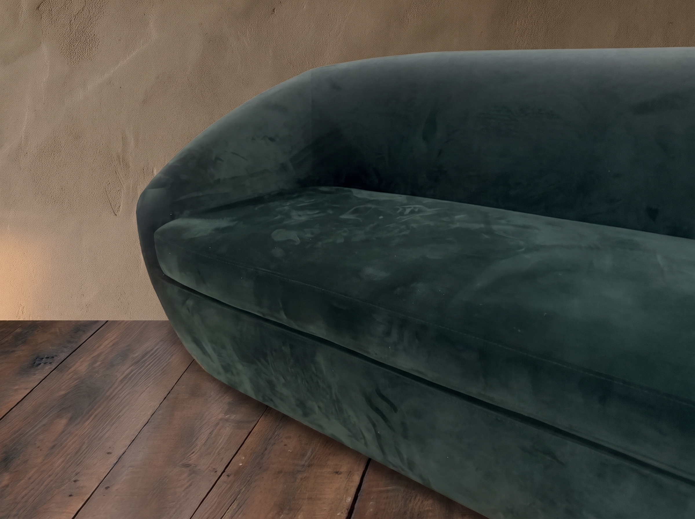 Detail of plush deep green velvet seat cushion and curved arm of a tub sofa