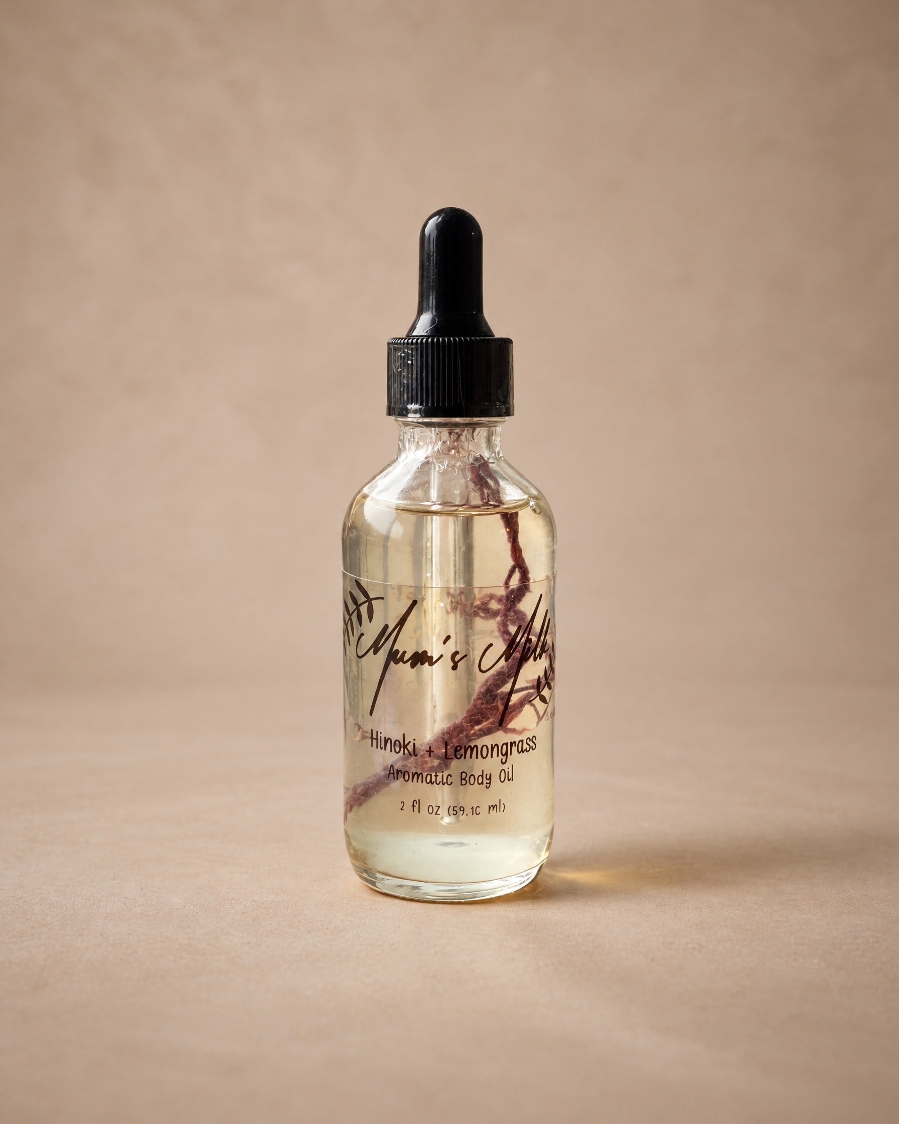 Hinoki + Lemongrass Aromatic Body Oil by Mum's Milk, glass dropper bottle with a dried botanical sprig