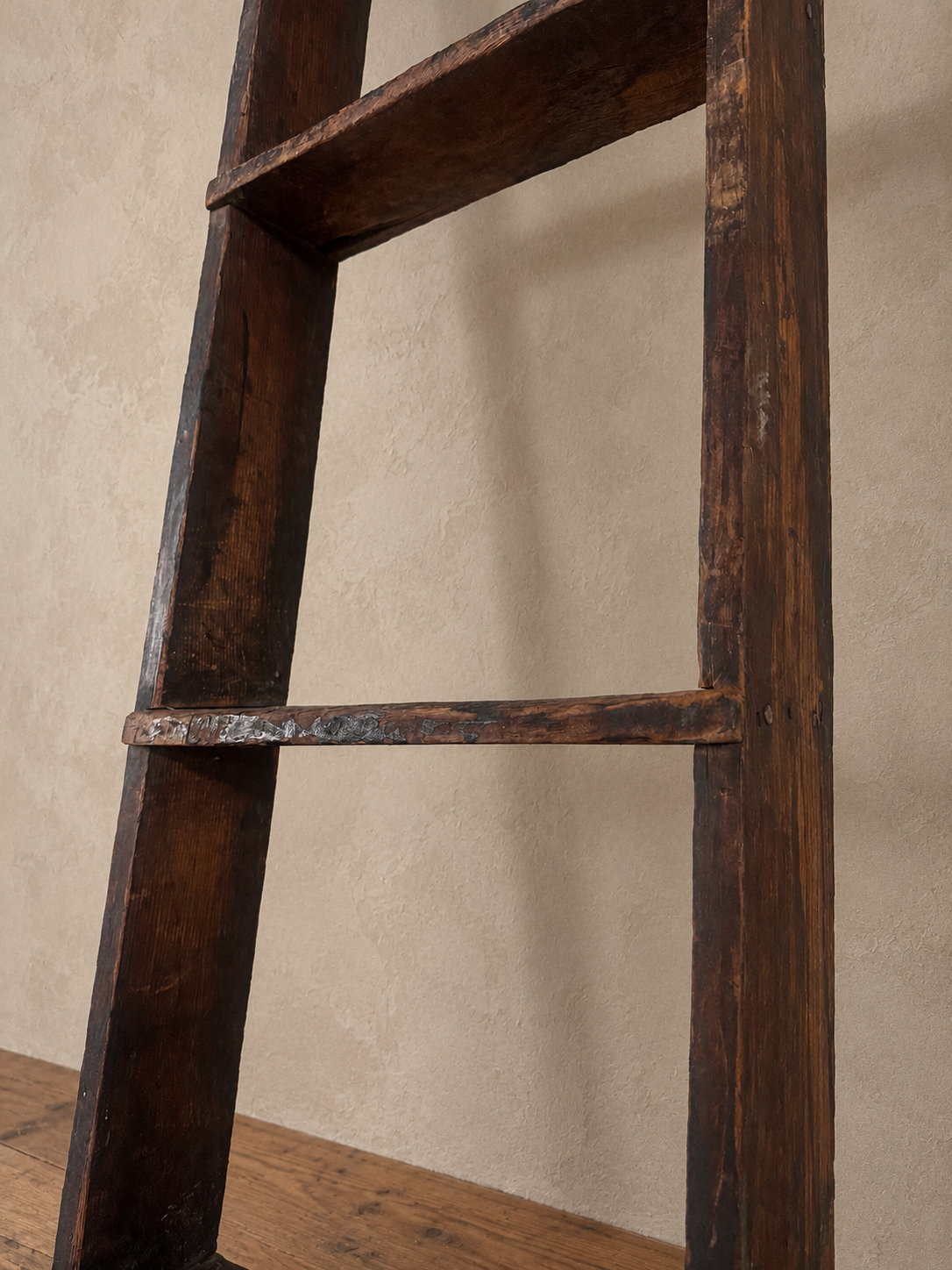 Detail of the ladder's weathered wood and worn rung edge