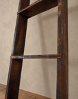 Detail of the ladder's weathered wood and worn rung edge