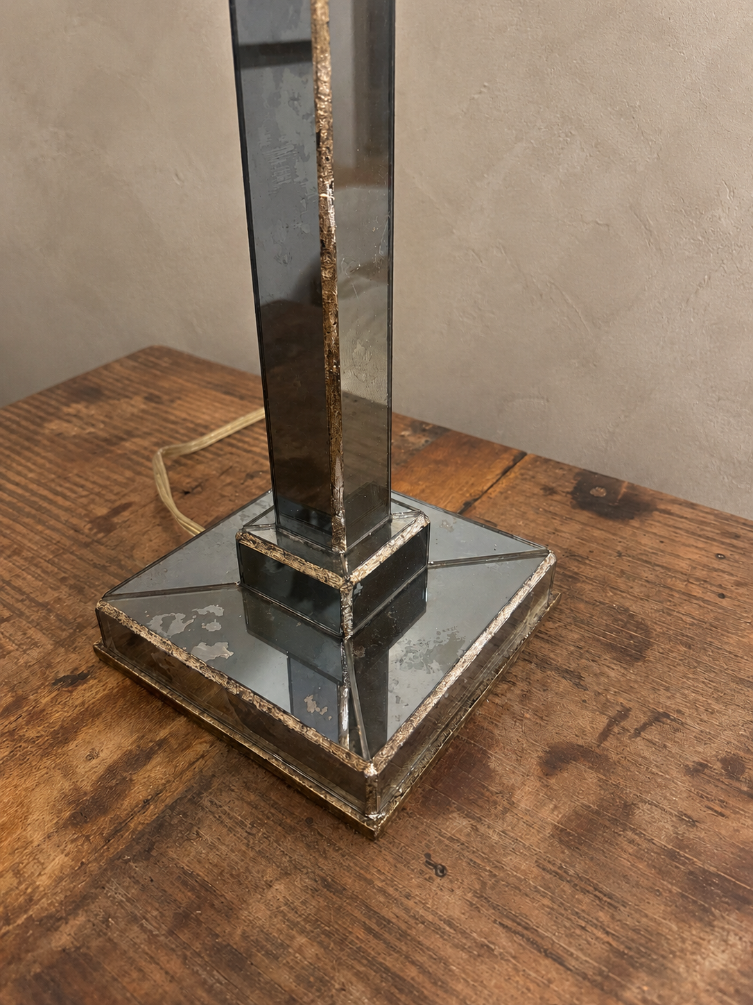 Close view of the lamp's stepped mirrored base and aged gold-toned edging