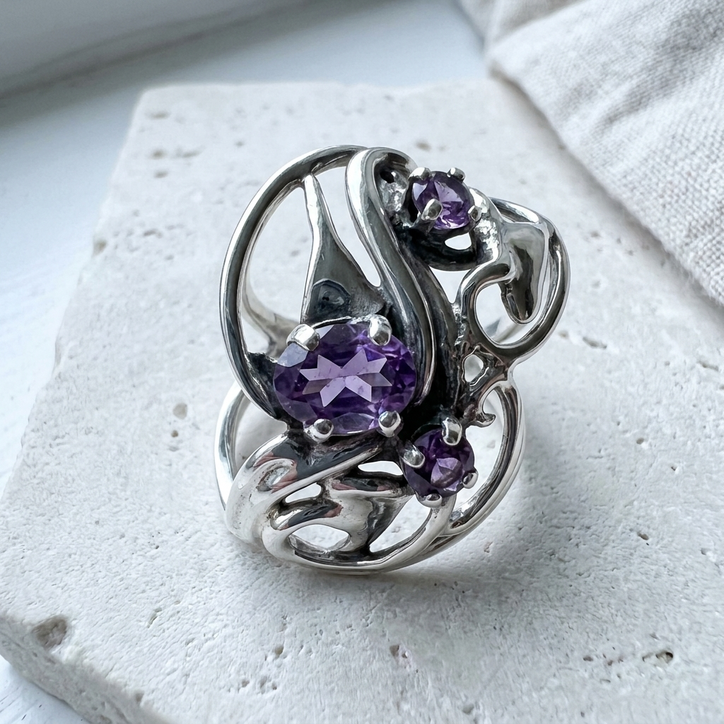 Wide domed sterling silver statement ring with sweeping open ribbon work and three amethysts