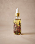 Rose + Cinnamon Aromatic Body Oil by Mum's Milk, glass dropper bottle with rose petals and cinnamon bark